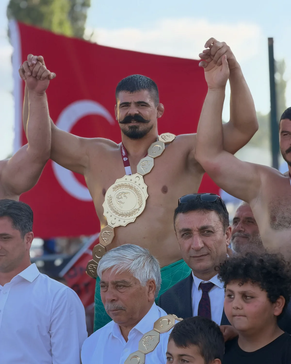 Kemer ve bayrakla zafer pozu
